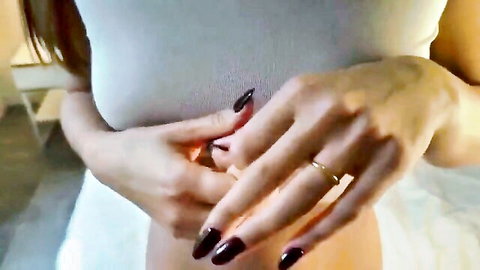 Brunette beauty teasing with manicured hands near crotch in white top