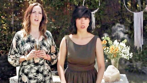 Two surprised women in floral and brown dresses at outdoor boho party