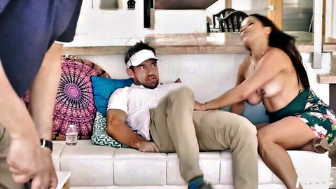Busty topless MILF grabs her huge bare tits while straddling man's lap as husband watches
