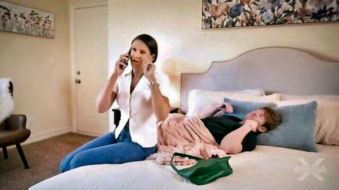 Penny Barber as Aunt Penny talks on phone beside nephew in bed