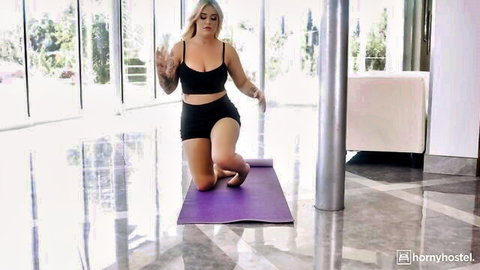 Kali Roses blonde bombshell in tight black sports bra and shorts, kneeling on yoga mat