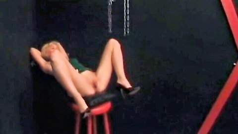 Skinny blonde spreads shaved pussy wide on red stool wearing black high heels
