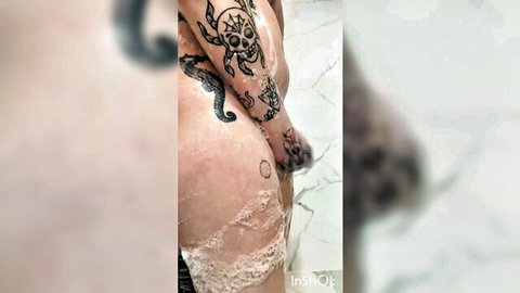MTF trans beauty in steamy soapy shower, showcasing tattoos and curves