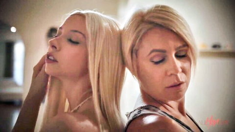 Mature blonde MILF intimately embraces topless young skinny blonde from behind in romantic lesbian pose