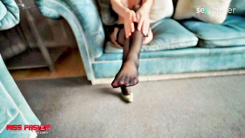 Nylon-clad babe spreads legs on couch fingering pussy while extending stocking foot
