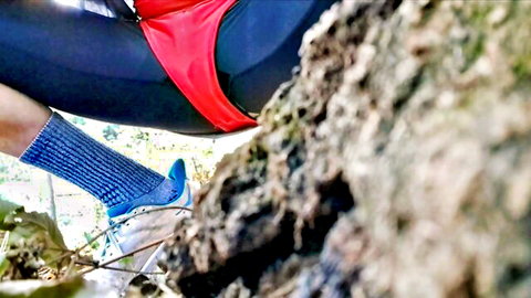 Trans babe pulls red swimsuit aside flashing hard cock and balls outdoors against tree