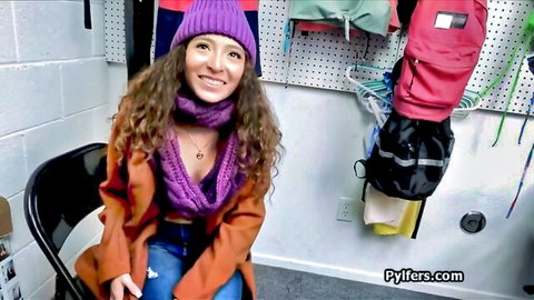 Smiling curly Latina in purple beanie and orange coat, teasing before cowgirl action