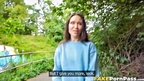Kristina Grace smiling in blue sweater outdoors in park, teasing look