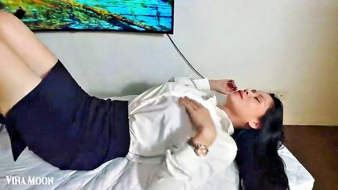 Vina Moon in office skirt and blouse lying relaxed on bed