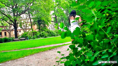 Jolee Love walks seductively in white top and shorts in green park