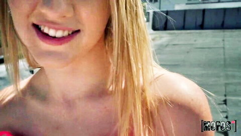 Smiling blonde teen beauty in enticing adult video close-up