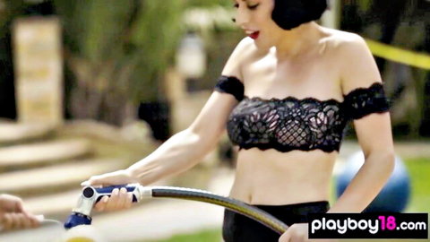 Asian babe in black lace bralette holding hose outdoors, playful tease