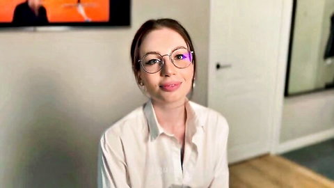 Seductive brunette in glasses and white blouse smiling alluringly