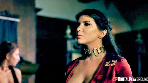 Romi Rain in fierce sultry red dress with gold choker, deep cleavage