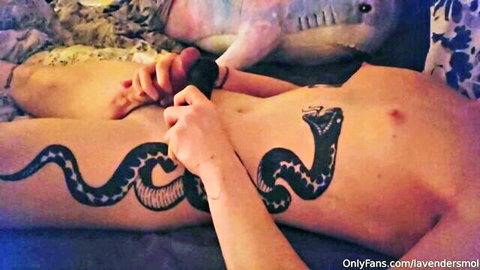 Tattooed babe spreads legs holding thick black dildo at wet pussy entrance