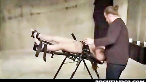 Submissive bound woman in BDSM session with man exploring her body