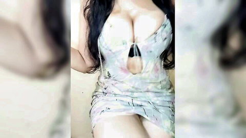 Queen-Walae in revealing white dress with deep cleavage, erotic pose
