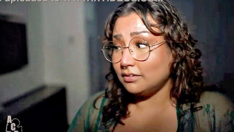 Curly-haired BBW with glasses in seductive indoor pose