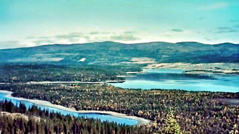 Scenic aerial view of turquoise lake, forests, and mountains in vintage style for Three Musketeers sex parody