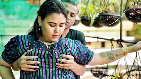 Curvy Indian BBW in striped dress cups her large breasts as man embraces from behind