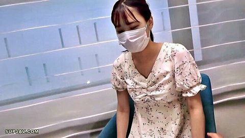 Asian woman in floral white dress and mask sitting in chair