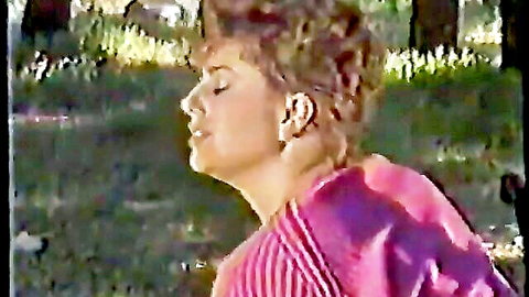 Vintage curly-haired white woman in ecstatic profile pose outdoors, pink top