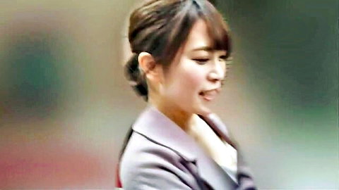 Asian woman in purple suit smiling sideways, soft focus