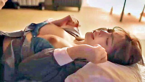 Asian woman lying topless in open shirt, relaxed pose on bed