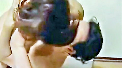 Asian woman arching back in passionate neck kiss with man, partial nudity