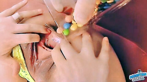 MILF inserting colorful chocolate candies into her wet pussy closeup