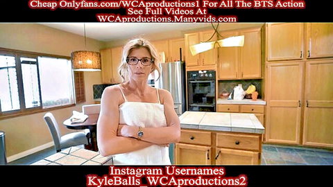 Busty blonde MILF with glasses poses seductively in kitchen wearing tight white slip dress