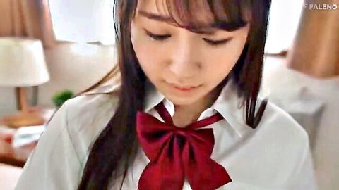 Cute East Asian schoolgirl in white blouse and red bow tie smiling seductively