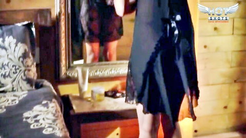 Sexy woman in black lace dress posing by mirror in bedroom