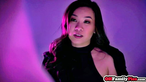 Seductive Asian woman in black cutout top, purple lighting gaze