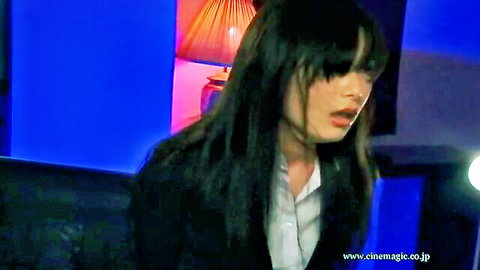 Seductive young Japanese woman with long black bangs opens mouth teasingly in open suit jacket