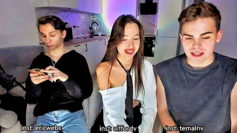 Cute young teen girl in off-shoulder top smiling wide between two guys on webcam kitchen tease