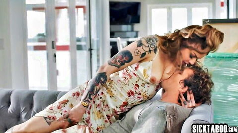 Tattooed blonde Vanessa Vega in flowing dress embracing man passionately