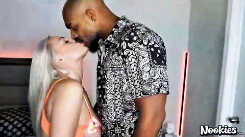 Blonde in skimpy orange lingerie passionately kissing muscular black stud
