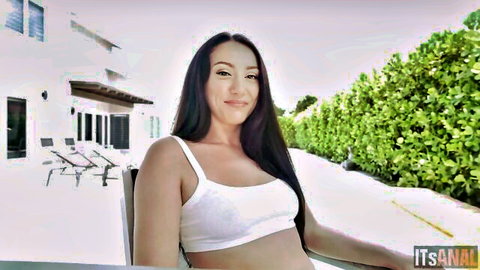 Sexy smiling Asian babe in tight white tank top showing cleavage poolside outdoors