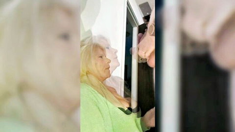 Blurry blonde MILF in green robe teases big tits cleavage by window reflection