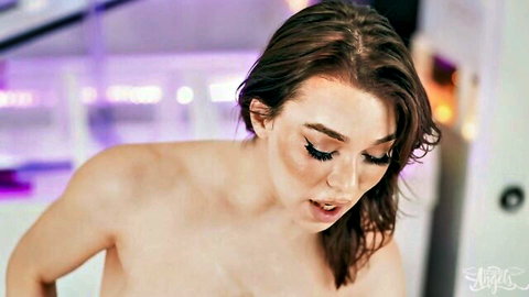 Topless brunette with heavy makeup and wide-open mouth in ecstasy under purple neon lights