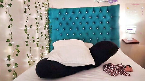 Big black curved dildo on pillows beside striped panties in sexy teal headboard bedroom