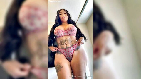 Tattooed thick ebony MILF in pink polka-dot lingerie pulling panties aside flashing shaved pussy and huge tits