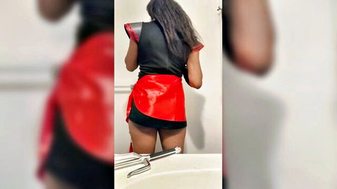 Sexy black woman in red mini skirt and black top, posing with ass out from behind