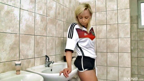 Blonde Naomi Nevena in sexy German soccer jersey posing in bathroom