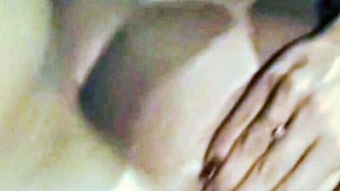 Blurry close-up of intertwined hands with wedding ring in intimate adult moment