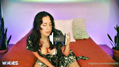 Brunette with deep cleavage whispers seductively into mic in ASMR solo tease
