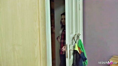 German step-sis Marie peeks in doorway, surprised expression in plaid shirt