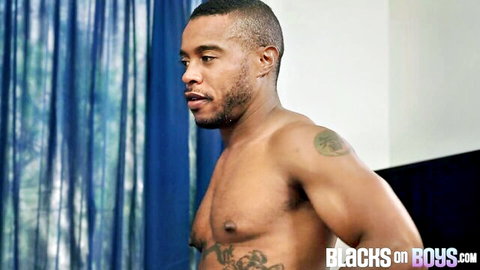 Muscular black man shirtless, tattooed arm, side profile pose