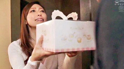 Smiling Japanese milf housewife holding gift box seductively, JAV scene